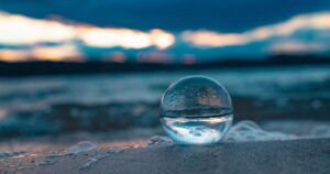 Glaskugel im Sand mit Spiegelung – Sinnbild für Wahrnehmung und Energie eines Reflektors im Human Design