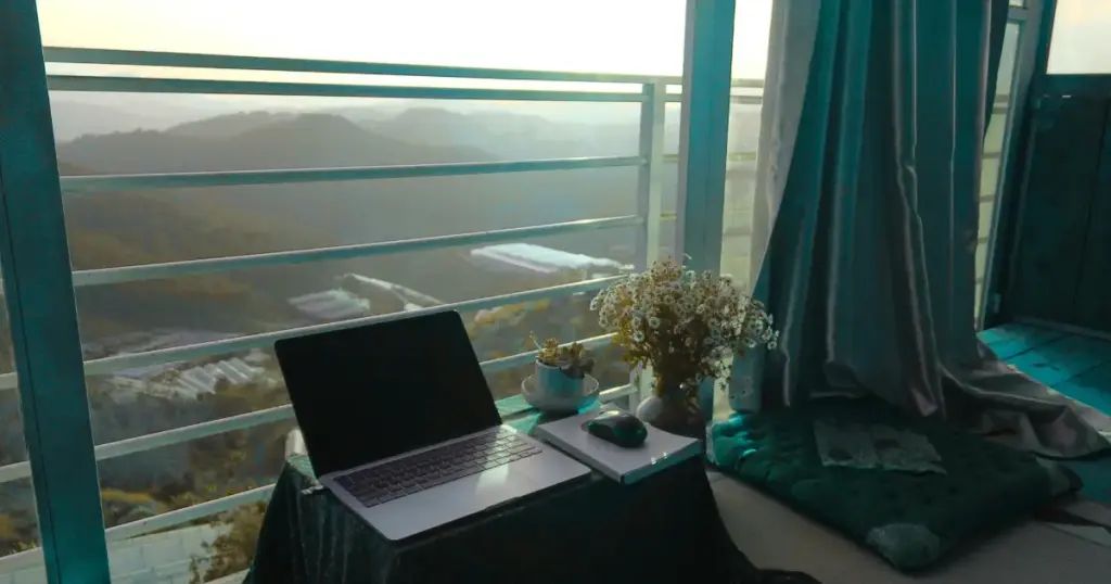 Ruhiger Arbeitsplatz am Fenster mit Laptop und Blick in die Natur als Arbeitsumfeld für Reflektoren im Beruf