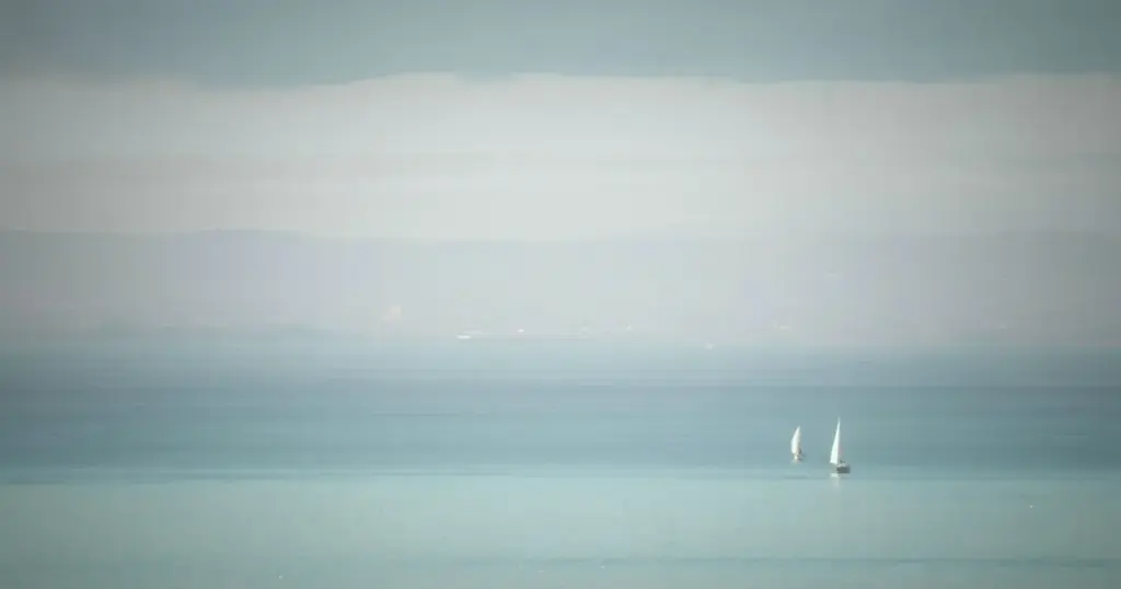Weite Wasserfläche mit zwei Segelbooten – Sinnbild für scheinbare Klarheit, die bei der Mondautorität des Reflektors oft missverstanden wird